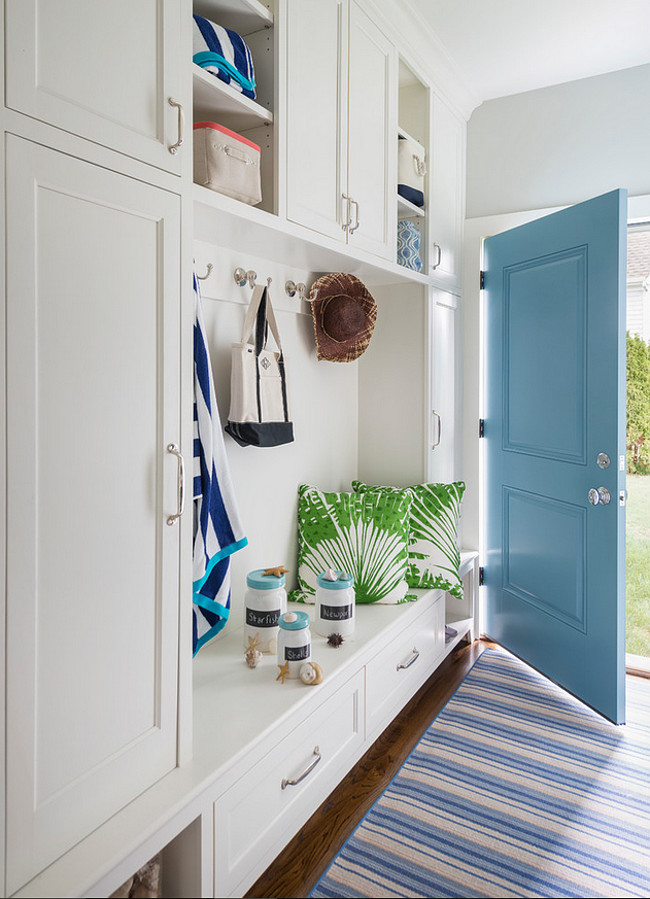 Mudroom. Turquoise door in mudroom. The mudroom features a wall of floor-to-ceiling built-in mudroom cabinets. The cabinets features a mudroom bench with drawers under overhead shelves. This space also boasts a white and blue stripe runner placed in front of a turquoise door. Isn't it this a perfect mudroom? #Mudroom #Turquoise #Door #PaintColor Digs Design Company. 