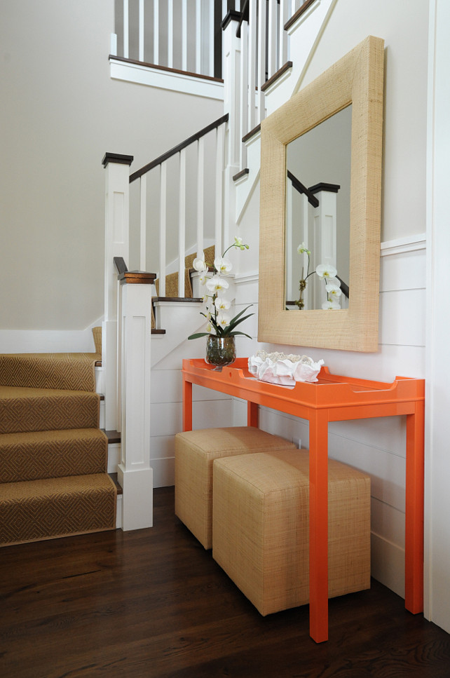 Foyer. Coastal Foyer. Coastal Entrance Foyer. With a hint of color, this stunning foyer features shiplap walls, a wraparound staircase with a sisal stair runner beside an Oomph Fenwick Console Table, with a pair of raffia wrapped poufs and a rectangular raffia mirror. #Foyer #Entryway #Entrance Nina Liddle Design.