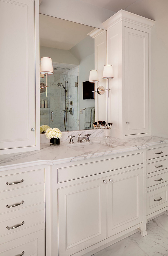 Bathroom Cabinet Ideas. Bathroom features his and her vanities with custom cabinetry, Calacatta marble, quality fixtures, and ample storage. White Bathroom Cabinet Design. #BathroomCabinet #BathroomCabinetry Bartelt.
