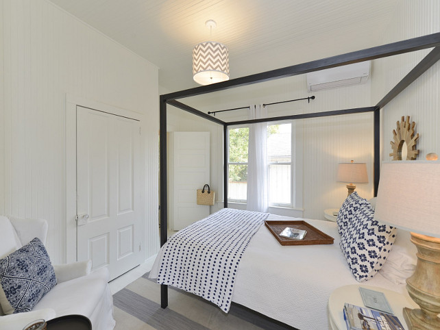 Coastal Bedroom with white beadboard walls and blue and white decor.