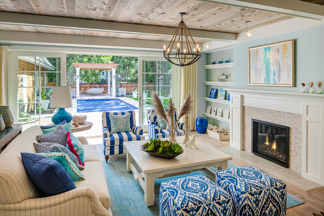 Family Room. Family room with reclaimed wood ceiling, blue walls, fireplace with shelves on the sideas, blue and white fabric and coastal decor. #FamilyRoom Great Neighborhood Homes.