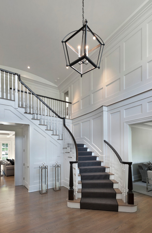 Foyer. Foyer paneling. Floor to ceiling recessed paneling graces the spacious two-story entry foyer with barrel vaulted ceiling. #Foyer #Paneling Blue Water Home Builders.