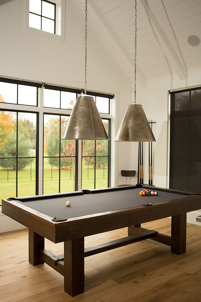 Game Room Lighting. Game room features a paneled cathedral ceiling lined with two Goodman Hanging Lamps suspended over a pool table. #GameRoom #Lighting #GoodmanHangingLamps Hahn Builders.