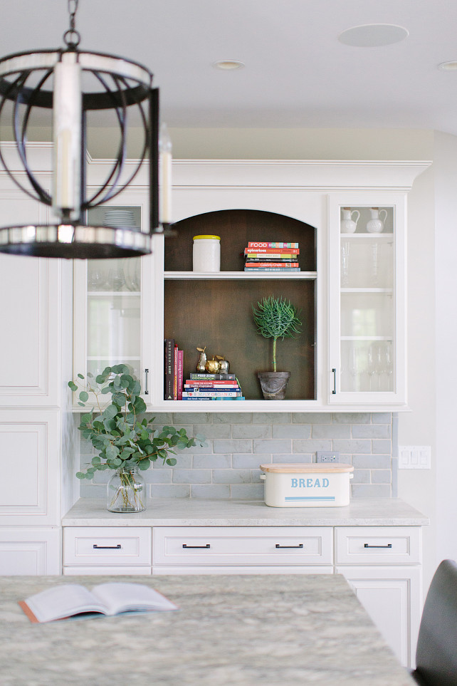 Kitchen Bookcase Cabinet. Beautiful kitchen features bookcase cabinet, white raised panel cabinets paired with white marble countertops and a blue beveled subway tiled backsplash. #Kitchen #Bookcase #Cabinet Kate Marker Interiors.