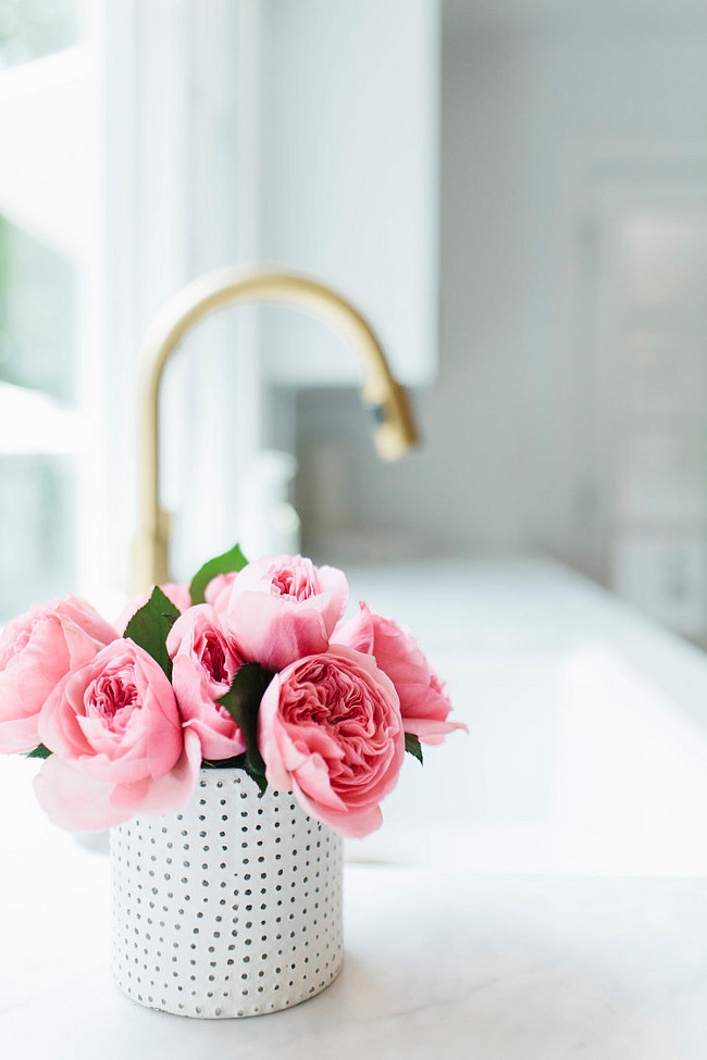 Kitchen Pink Peonies. Beautiful pink peonies in kitchen with white marble countertop and gold kitchen faucet. #kitchen #PinkPeonies #WhiteMarble #GoldFaucet #KitchenFaucet Shea McGee Design.
