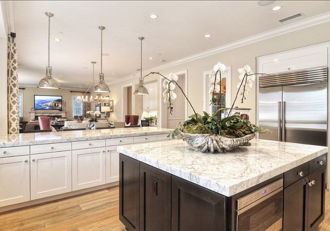 Kitchen. Kitchen Island Ideas. Kitchen Island Design. Kitchen. White and gray granite countertops sit atop white cabinets and a large, dark wood island. #Kitchen #KitchenIsland #KitchenIdeas