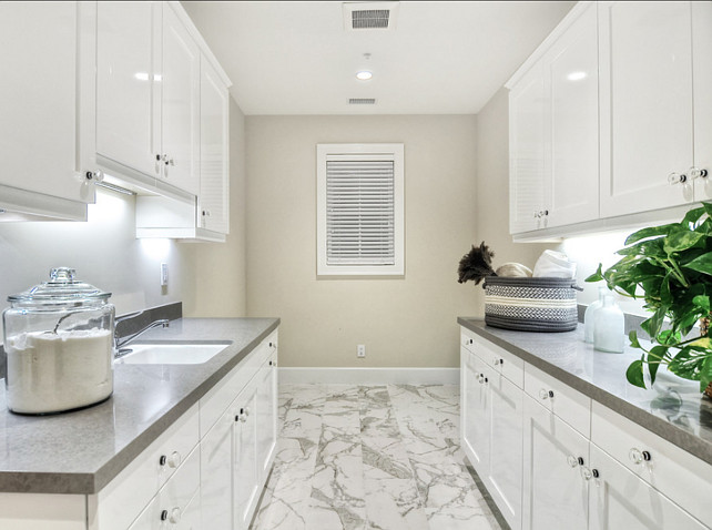 Laundry Room. Laundry Room Ideas. Bright, shiny, white cabinets create a clean look in this spacious laundry room. #LaundryRoom #LaundryRoomIdeas #LaundryRoomDesign #LaundryRoomCabinet #LaundryRoomCountertop