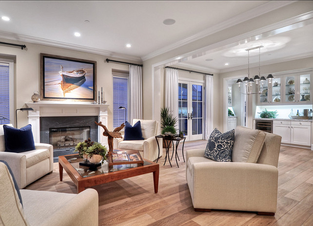 "Benjamin Moore HC-80 Bleeker Beige". Living Room Ideas. Beach accents and artwork create a coastal feel in this bright and open living room. Off white, oversized occasional chairs surround a glass topped wooden table. #LivingRoom