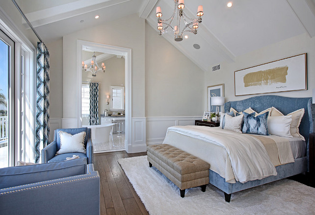 Master Bedroom with blue wing bed, blue chairs, ivory rug area, creamy white walls and a stunning polished nickel chandelier. #Bedroom #MasterBedroom Spinnaker Development.