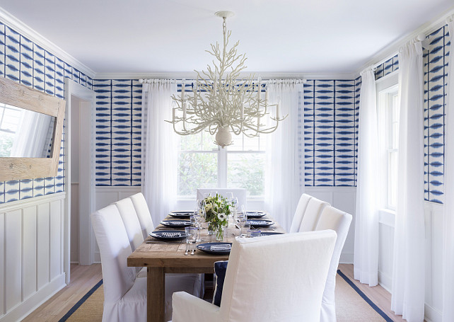 Dining room. Bleached wood floors, sisal rug, slipcovered white cotton chairs, blue and white wallpaper and white sheer drapery. Chandelier is the Natural Sand Twelve-Light Chandelier. Natural Sand Twelve-Light Chandelier. This reclaimed wood table came from RH. #CoastaInteriors #DiningRoom #CoastalDiningRoom #DiningRoom Chango & Co.