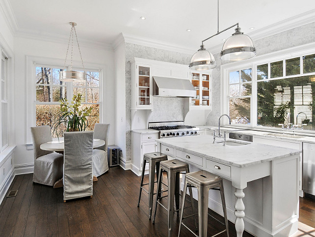 Small Crisp white kitchen with breakfast nook. Via Sotheby's Homes.