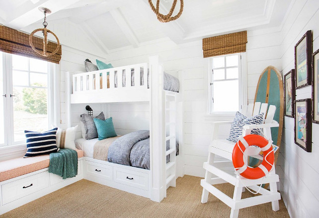 Tongue and groove bunk room. This white Bunk room features white bunk bed with gray bedding, turquoise decorative pillows, rope pendant lighting, bamboo shades, window seat, sisal carpeting and shiplap walls. Coastal bunk room with tongue and groove walls. #Bunkroom #TongueandGroove #CoastalInteriors Blackband Design.