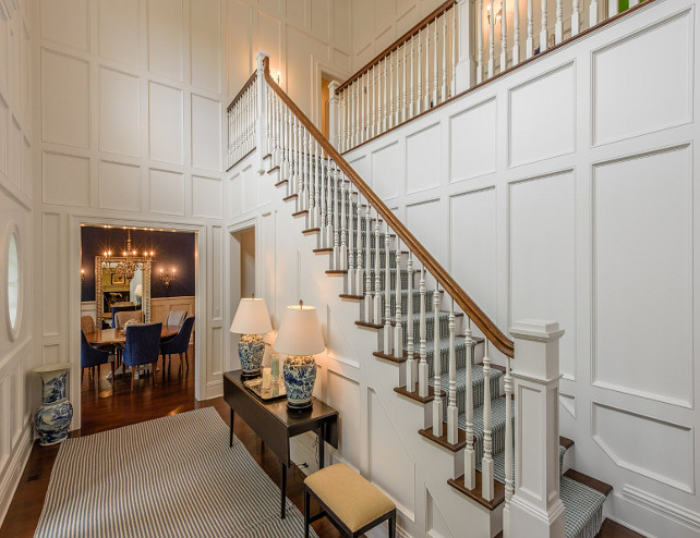 Traditional Foyer with wraparound staircase and paneled walls. Wall paneling foyer ideas. #TraditionalFoyer #Foyer #PaneledWalls #WallPanelling Via Sotheby's Homes.