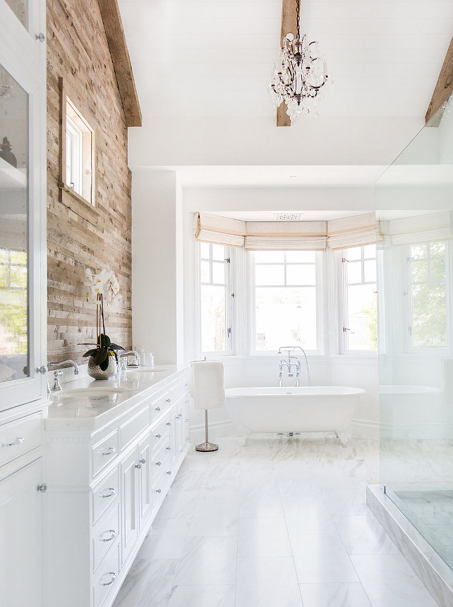 White Bathroom. White Bathroom with reclaimed wood accent wall, ceiling beams, vaulted ceiling, French chandelier, marble floor tiling, bay windows and freestanding bathtub. #Bathroom Blackband Design.