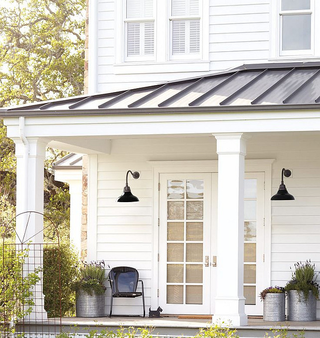 White Exterior Siding Ideas. Metal roof, lanterns and planters. Cassic white house with black accents. Via Rejunenation.