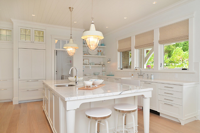 White kitchen with turquoise decor. I love the turquoise decor, the neutral blinds and the glass cabinet above the refrigerator. The kitchen island countertop is a polished 3/4" white marble slab called Bianco Statuario. Sunshine Coast Home Design.