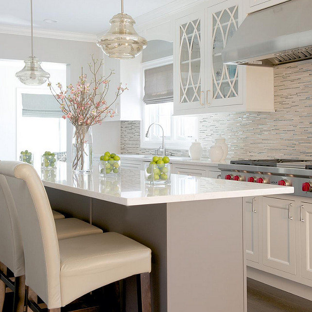 Caesarstone Frosty Carrina. Light grey island with cream color cabinets are balanced with the multi-color glass tiles. Soft hues of grey and cream are carried throughout the kitchen. #kitchen #Caesarstone #FrostyCarrina. Color Concept Theory.