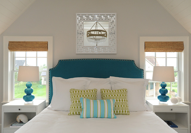 Beach House Bedroom. Coastal Beach House Bedroom. White greek key mirror greek key framed mirror mirror over headboard peacock blue headboard peacock blue headboard with nailhead trim modern white nightstand two drawer nightstand peacock blue lamp peacock blue gourd lamp peacock blue triple gourd lamp white bed linens white sheets white euro shams chartreuse pillow chartreuse geometric pillow aqua blue striped pillow sash window bed between windows nightstands in front of windows blue walls blue wall color vaulted ceiling tongue and groove vaulted ceiling clear beaded chandelier beaded jute chandelier woven window shades greek key mirror square greek key mirror mirror above headboard peacock blue bed peacock blue velvet bed peacock blue velvet bed peacock blue table lamps Ro Sham Beaux Frankie Beaded Chandelier Robert Abbey Triple Gourd Lamp Peacock.