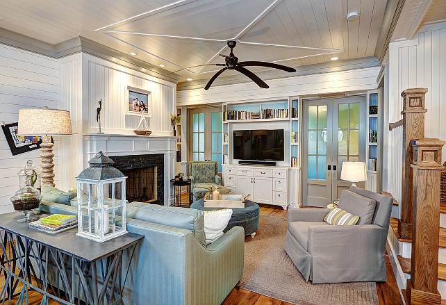 Living Room. blue ottoman, blue sofa, built in bookshelves, ceiling fan, framed photo, french doors, glass doors, gray armchair, recessed lighting, tongue and groove, white ceiling, white fireplace mantel Ink Architecture.