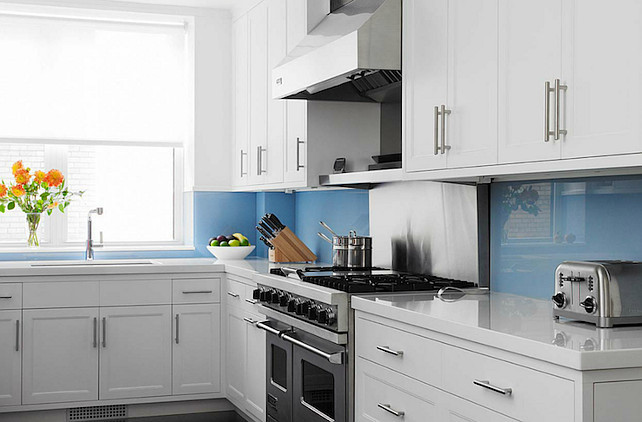 Glass Backsplash. Coastal kitchen with blue glass backsplash. White & blue kitchen design with crisp white kitchen cabinets with white quartz countertops and blue backsplash. #kitchen #GlassBacksplash John B Murray Architect.