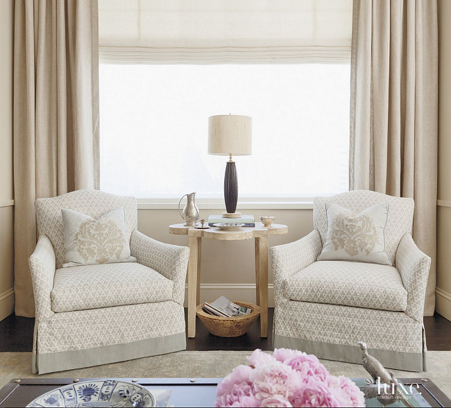 Living room. Living room chairs. Lounge chairs by Lee Industries, covered in a Quadrille fabric, provide seating with a view in the living room. The custom pillows are clad in a damask fabric from Cowtan & Tout; a reclaimed-wood coffee table from Noir is topped with a lamp by Ro Sham Beaux. Jenny Wolf Interiors.