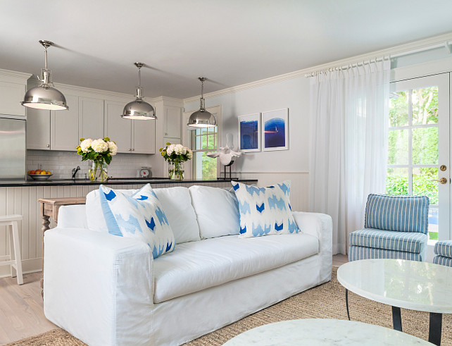 Kitchen and family room. Family room and kitchen. Honed soapstone countertops, wainscoting on walls, bleached oak floors, white slipcovers sofa and cotton striped chairs. Marble top round tables with hot rolled steel bases. #Kitchen #FamilyRoom 