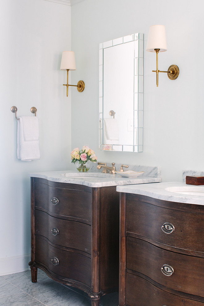 Bathroom. Bathroom with tiled mirrors flanked by Thomas O'Brien Bryant Sconces in Hand Rubbed Antique Brass situated above his and her vanities accented with brass faucets topped with white marble and paired with tiled mirrors. Natalie Clayman Interior Design.