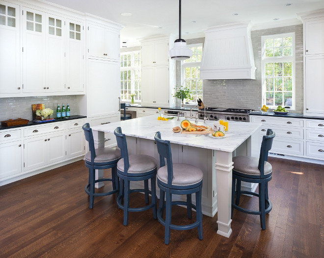 Classic white kitchen with hardwood, carrara marble countertop on island and black granite countertop on perimeter cabinets. #kitchen John Kraemer & Sons.