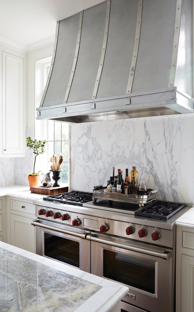 Kitchen Marble Slab Backsplash. Marble Slab Backsplash Behind Range. White Marble Slab Backsplash. Kitchen with a zinc French kitchen hood is placed above a marble cooktop backsplash and Wolf Range flanked by windows. #Kitchen #Marble #Slab #Backsplash Cyndy Cantley. Birmingham Home and Garden.