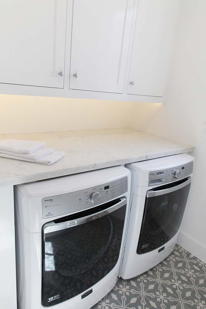 Laundry Room. White laundry room cabinet with gray cement tiles. #LaundryRoom #CementTiles Graystone Custom Builders.