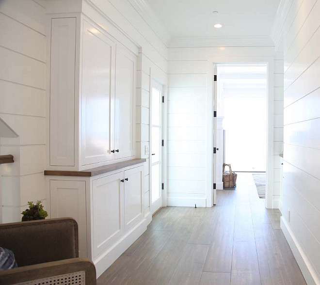 Stairway Landing with shiplap walls, graywashed hardwood floors and built-in cabinet. Graystone Custom Builders.