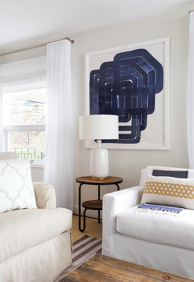 Blue and white living room. Neutral living room with blue and white decor. Blue and white coastal interiors. Blue and white art is by Art is from English Country Antiques. Side table is from Noir Furniture and table lamp is by Currey and Co. #Blueandwhite #livingroom #interiors #EnglishCountry #Antiques Chango & Co. 