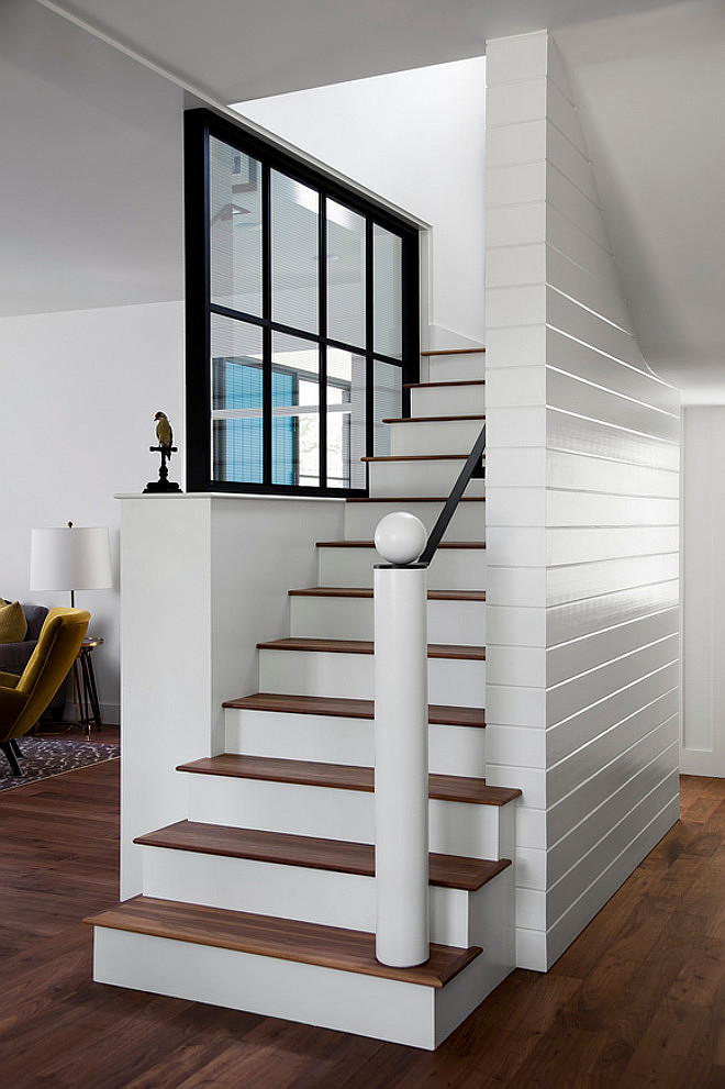 V-groove, tongue and groove wood siding Stairway. Foyer with V-groove, tongue and groove wood siding stairway. Window is walnut painted in black. #Vgroove #tongueandgroove #woodsiding #foyer #Stairway Tim Cuppett Architects.