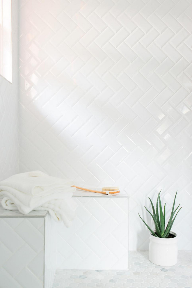 An inexpensive alternative to more pricey tiles, simple subway tiles were installed in a herringbone pattern in the shower. White grout between the tiles lends a more cohesive look.