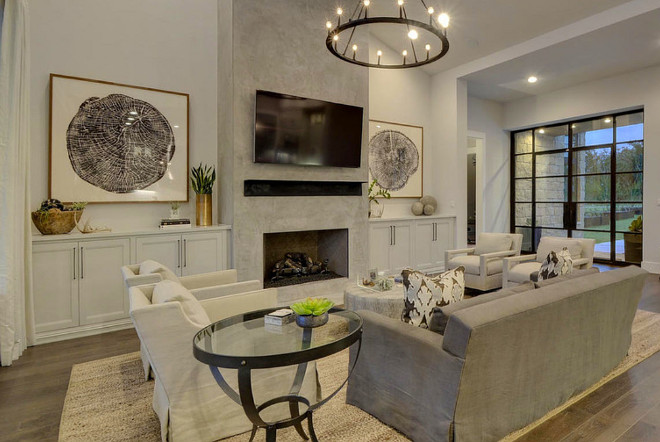 Concrete Fireplace. Living room with concrete fireplace and sloped ceiling. Concrete fireplace with built in cabinets on sides. #ConcreteFireplace Geschke Group Architecture.