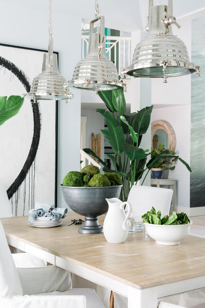 Dining Room Lighting. A trio of industrial-style pendants made from polished nickel offer illumination over the dining table.