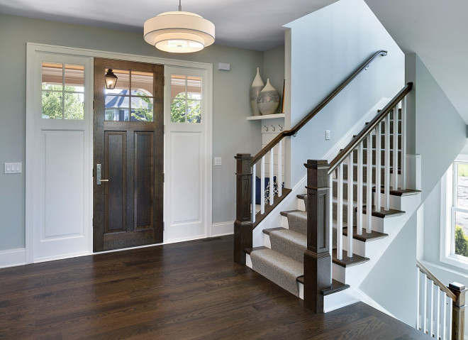 Foyer. Grey Foyer with Hardwood Floor and Built-in Bench in small nook by the stairway. #Foyer. #GreyFoyer Spacecrafting Photography. Carl M. Hansen Companies.