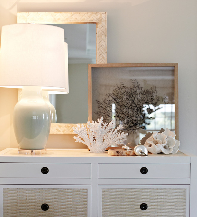 White dresser with coastal vignette. White dresser with coastal decor - vignette. White dresser with coastal decor, inlaid bone mirror, grass cloth, coral art, seashell, sea glass, sea foam green.