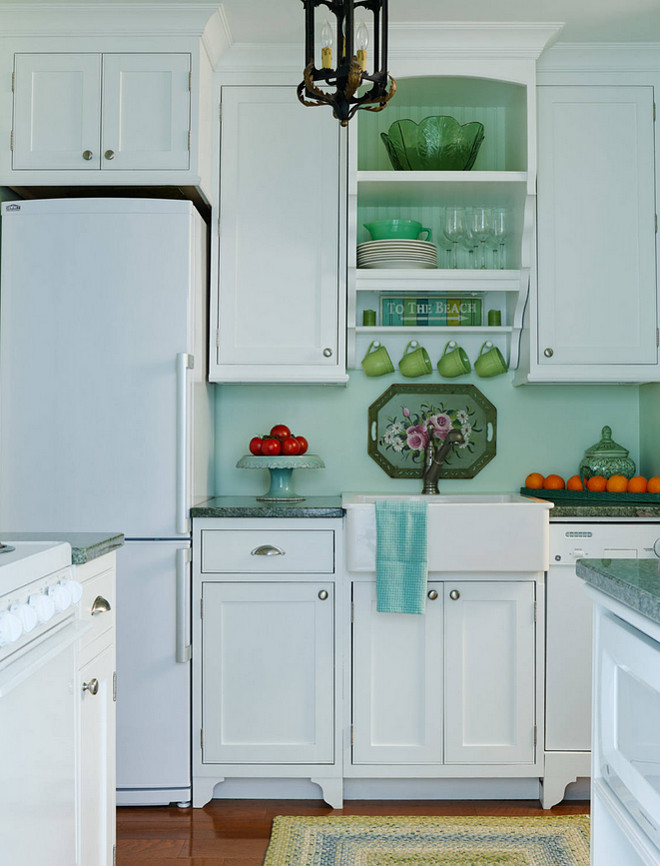 Small Kitchen Photos, ideas and tips. The cabinets were made by a local craftsman and are made of maple. The designer painted them after they were installed. The farmhouse sink is the Domsjo sink from Ikea. It's about 24"x27" Domsjo sink. The light fixture is vintage, bought at an antique place in Michigan. The refrigerator is a Summit. Paint Color is Gratifying Green from Sherwin Williams. #SmallKitchen #Kitchen #KitchenPhotos #KitchenTips #Kitchenideas #Smallkitchens