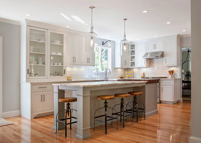 White kitchen with gray island paint color. The white kitchen cabinet paint color is called Cottonball, from Pennville Custom Cabinetry. The gray island paint color is Benjamin Moore Fieldstone. #Whitegraykitchenpaintcolor #Grayislandpaintcolor #BenjaminMooreFieldstone Pennville Custom Cabinetry