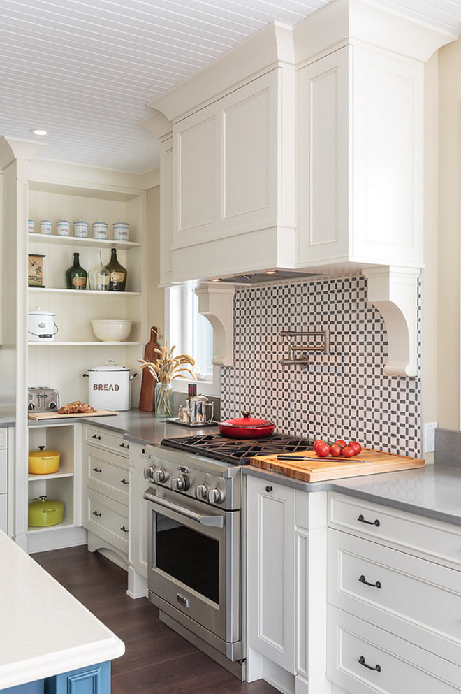 The range wall is one of the focal points of this kitchen, thanks to the marble backsplash, corbels and a hood vent. The hood vent has some storage as well; the panels on the end conceal touch-latch cabinets. The backsplash is a custom mix of Grise Savoie and Thassos marble. Range is by Thermador. The hood backsplash is a custom mix of Grise Savoie and Thassos marble #hood #kitchenhood #kitchenbacksplash #GriseSavoie #Thassosmarble