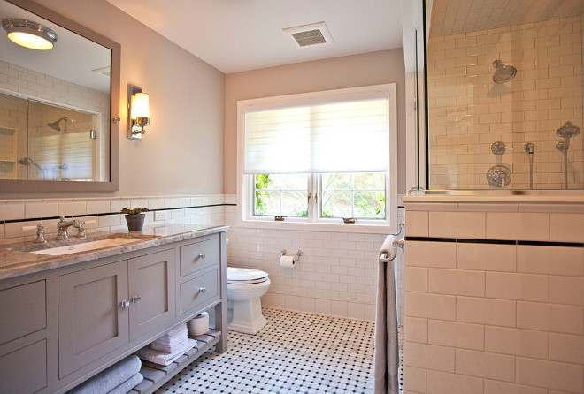 A fresh approach to classic style completely transformed this master bathroom. Soft gray walls, white subway tile and marble flooring exemplify the feeling of casual luxury. The large medicine cabinet and generous vanity with open shelf provide ample storage space. TreHus Architects+Interior Designers+Builders.