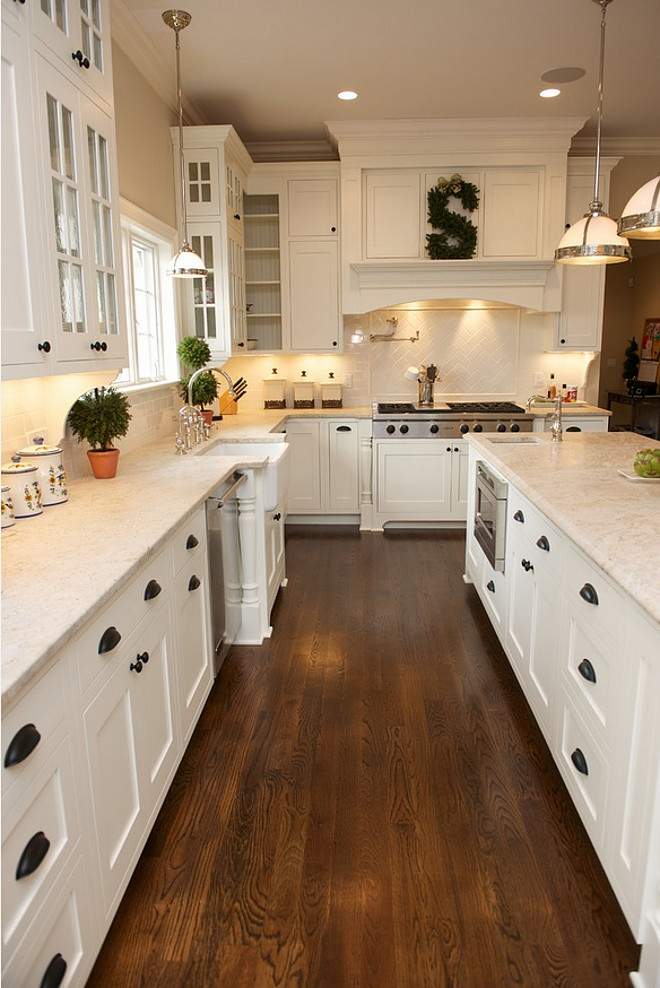 This is a traditional kitchen with contemporary features. Painted white, shaker style inset cabinetry. Dramatic wood hood. Glass door wall cabinets. #kitchen East Hill Cabinetry