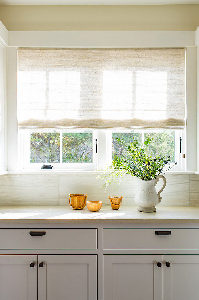 Kitchen window treatment ideas. Neutral Kitchen window treatment. Neutral kitchen with Linen Shades. A neutral linen shade softens this off-white kitchen. #kitchen #Windowtreatment #KitchenWindow #Kitchenwindowshades #kitchenRomanShades Martha's Vineyard Interior Design