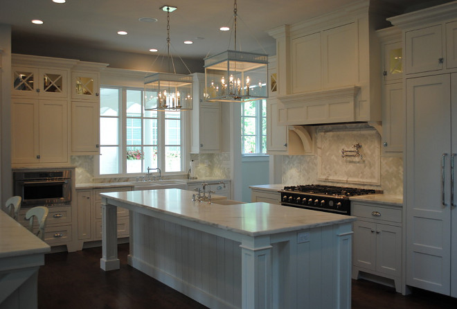 White kitchen. Inset cabinet. White kitchen with inset cabinets. This kitchen features clean lines, inset cabinets, Imperial Danby Marble, Urban Electric pendants, Herringbone backsplash, La Cornue Range in black. #Whitekitchen #kitchen #insetcabinets #inset #insetkitchencabinets Stacye Love Construction & Design, LLC