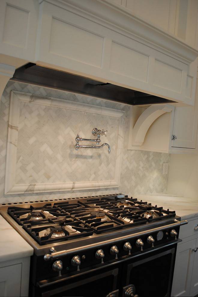 Kitchen backsplash. La Cornue Range, Waterworks pot filler, Custom hood, Backsplash in Honed Carrara Marble in Herringbone, Counters in Honed Imperial Danby. #Kitchen #backsplash Stacye Love Construction & Design, LLC