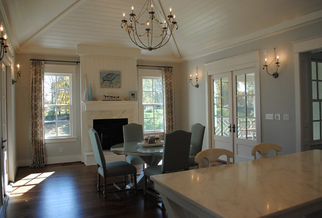 Eat in kitchen. Eat-in kitchen with french doors leading to an outdoor dining porch with fireplace, vaulted, beamed ceiling, chandelier and sconces from Low Country, kitchen table custom by Stacye Love, counters in Honed Imperial Danby, paint Benjamin Moore HC 171 Wickham Gray. #eatinKitchen Stacye Love Construction & Design, LLC