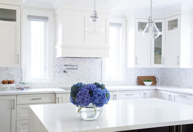 Crisp white kitchen painted in Benjamin Moore White Dove OC-17 and marble backsplash tile in herringbone pattern. barlow reid design