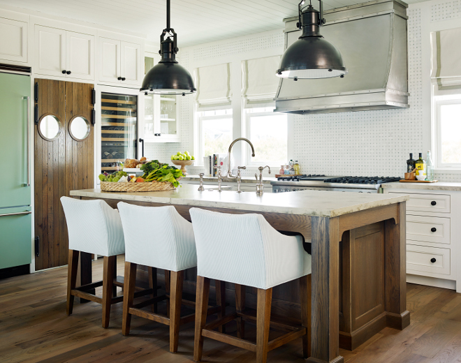 Coastal kitchen. This coastal kitchen features plenty of storage, workspace and character. I am loving the walnut stained island and the swing doors with porthole windows. Pendants are Large Country Industrial Pendant from Circa Lighting. #CoastalKitchen #CoastalKitchenlighting #Coastallighting #kitchenpendants #LargeCountryIndustrialPendant #CircaLighting #CircaLightingPendants T.S. Adams Studio, Architects