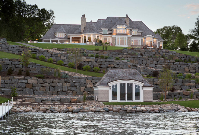 Lake house. Lake house A stunning beautiful boathouse and a winding bluestone retaining wall that lines the path up to the home where you will find three tiers of paver patios complete with an outdoor kitchen, firepit, hot tub, infinity swimming pool and a lot of entertaining space. #lakehouse #lakehouseexterior Southview Design. Eskuche Design.